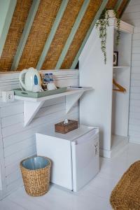 a white kitchen with a shelf and a basket at D'Yuki Huts Lembongan in Nusa Lembongan