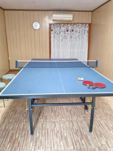 a blue ping pong table in a room at guest house mami in Taketa +9 photos