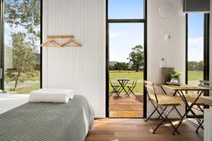 a bedroom with a bed and a table and chairs at Halls Haven Tiny House 1 by Tiny Away in Halls Gap