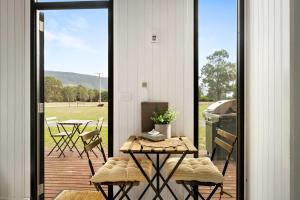 a screened in porch with a table and chairs at Halls Haven Tiny House 1 by Tiny Away in Halls Gap
