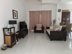 a living room with a couch and chairs and a tv at Penang Gelugor Landed House 4Rooms 3 Bathrooms in Gelugor