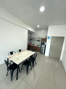 a table and chairs in a room with a kitchen at Peace Homestay 2 in Brinchang +1 photo