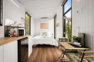 a bedroom with a bed and a table in a room at Halls Haven Tiny House 2 by Tiny Away in Halls Gap