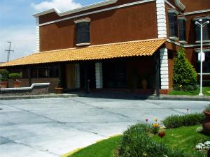 a large building with a straw awning on it at Hotel San Jeronimo Inn in Toluca