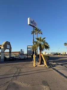 a motel sign on a street with palm trees at MHO Hotel Eloy Casa Grande Near I-10 in Eloy