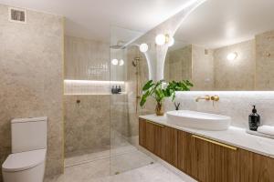 a bathroom with a toilet and a sink and a shower at CASA AMELIA - Boutique Studio in Port Douglas