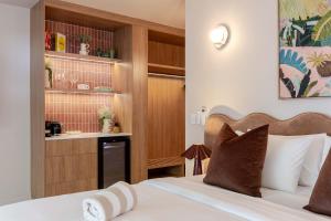 a hotel room with a bed and a kitchen at CASA AMELIA - Boutique Studio in Port Douglas