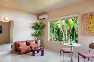 a living room with a table and chairs and a window at CASA AMELIA - Boutique Studio in Port Douglas
