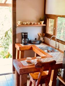 a kitchen with a sink and a table with chairs at Quirama Lodge Oriente Antioqueño in Carmen de Viboral