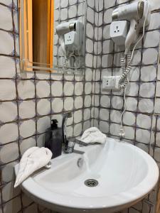 a bathroom sink with a hair dryer and a mirror at Arte Pyramids Hotel in Cairo