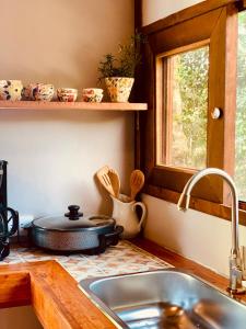 a kitchen with a sink and a stove and a window at Quirama Lodge Oriente Antioqueño in Carmen de Viboral +30 photos