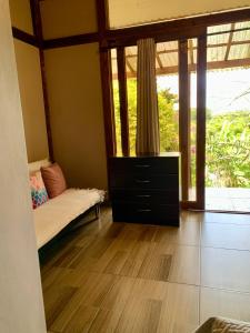 a bedroom with a bed and a dresser with windows at Quirama Lodge Oriente Antioqueño in Carmen de Viboral
