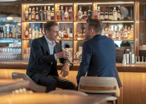 two men in suits sitting at a bar at TeoDorka Med & SPA in Ciechocinek