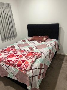 a bedroom with a bed with a quilt on it at 1 Spacious bedroom available in Auckland