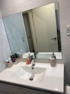 a bathroom sink with a large mirror above it at 1 Spacious bedroom available in Auckland