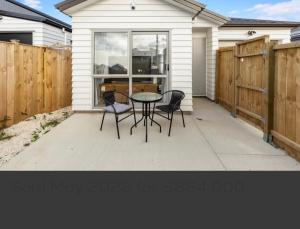 a patio with a table and chairs in front of a house at 1 Spacious bedroom available in Auckland