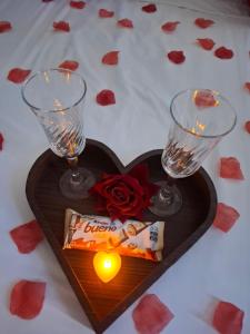 a heart shaped plate with a candle and two wine glasses at Pousada Colibris da Barra da Tijuca in Rio de Janeiro