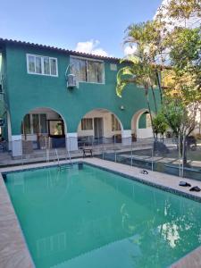 a swimming pool in front of a house at Pousada Colibris da Barra da Tijuca in Rio de Janeiro