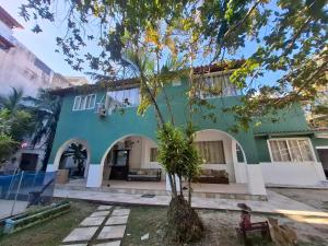 a green house with a tree in front of it at Pousada Colibris da Barra da Tijuca in Rio de Janeiro