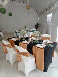 a table in a white tent with white chairs and a table withbons at San Mateo Hotel Campestre in Nobsa