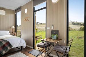 a bedroom with a bed and a table and chairs at Tiny Regen Farm Stay by Tiny Away in Lawrence