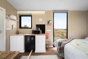 a bedroom with a kitchen with a microwave and a bed at Tiny Regen Farm Stay by Tiny Away in Lawrence +11 photos
