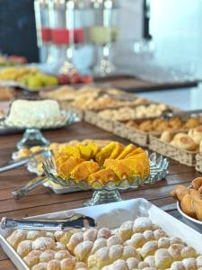 a table topped with different types of pastries and bread at Hotel Santorini in Trindade +36 photos