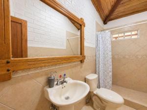 a bathroom with a sink and a toilet and a mirror at Luxury Quinta con Jacuzzi - Sauna - BBQ in Cusúa