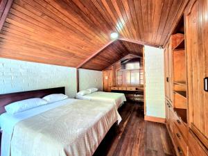 a bedroom with two beds and a wooden ceiling at Luxury Quinta con Jacuzzi - Sauna - BBQ in Cusúa +15 photos