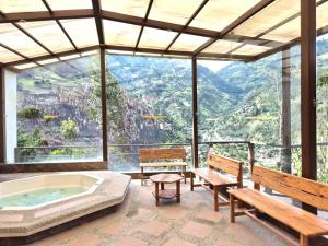 a room with benches and a tub with a view at Luxury Quinta con Jacuzzi - Sauna - BBQ in Cusúa