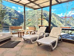 a patio with chairs and tables and mountains in the background at Luxury Quinta con Jacuzzi - Sauna - BBQ in Cusúa