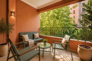 a balcony with chairs and a table and a window at Luxury Apartment with Private Jacuzzi & Pool Central Marrakech in Marrakesh