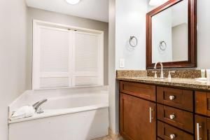 a bathroom with a tub and a sink and a mirror at Resort Studio with Nature Preserve Views in Destin