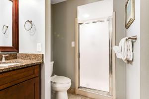a bathroom with a toilet and a glass shower at Resort Studio with Nature Preserve Views in Destin