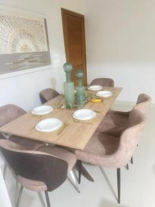 a dining room table with chairs and a wooden table with green vases at Dominican paradise in Punta Cana +8 photos