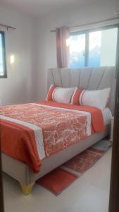 a bed in a room with a large window at Dominican paradise in Punta Cana