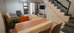 a living room with a table and chairs and a staircase at Mike's Staycation in Clark in Angeles