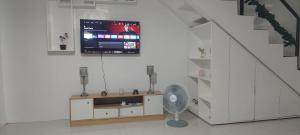 a room with a fan and a tv on a wall at Mike's Staycation in Clark in Angeles
