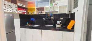 a kitchen with white cabinets and a black counter top at Mike's Staycation in Clark in Angeles