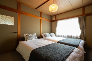 two beds in a room with a window at good day biei in Biei