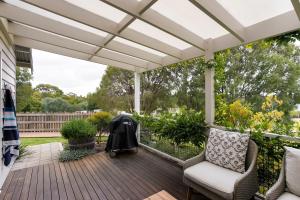 a patio with a white pergola and chairs at Stablebase in Albany