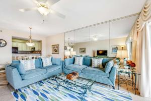 a living room with two blue couches at TOPS'L Summit 1013 in Destin
