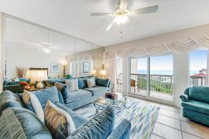 a living room with blue couches and a large window at TOPS'L Summit 1013 in Destin