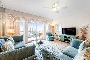 a living room with couches and a flat screen tv at TOPS'L Summit 1013 in Destin