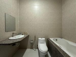 a bathroom with a toilet and a sink and a tub at SEAMOON Hotel in Rạch Giá +9 photos