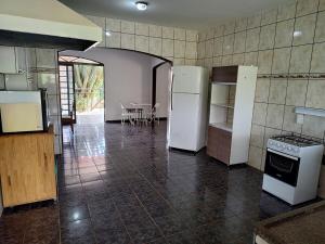 a kitchen with white appliances and a table in a room at Area de Lazer Rural in Ribeirão Preto