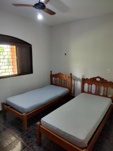two beds in a room with a ceiling fan at Area de Lazer Rural in Ribeirão Preto +47 photos