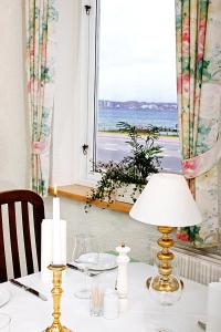 a table with a lamp and a view of the ocean at Sølyst Kro- Restaurant og Hotel I/S in Aabenraa +41 photos
