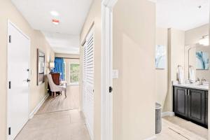 a hallway with a bathroom with a sink and a mirror at TOPS'L Summit 207A in Destin