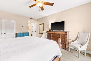 a bedroom with a bed and a flat screen tv at TOPS'L Summit 207A in Destin